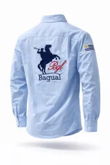 Camisa de manga larga color rosa, con cuello clásico y botones frontales. Presenta un bordado en la espalda con la figura de un gaucho a caballo, el logo de la marca Bagual y una pequeña bandera de Uruguay en la manga.