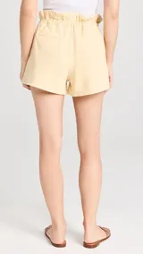 Short amarillo de tiro alto con gran volumen, elástico en la parte trasera y cordón de ajuste en la cintura.