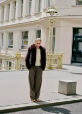 Chaqueta de pelo sintético en color marrón oscuro, con diseño recto, cuello solapa, cierre frontal con cremallera y manga larga.