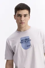 Remera de manga corta color marrón, con escote redondo y estampado frontal con la frase "Never Give Up" y el logo de la marca Mistral.