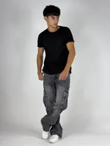 Pantalón de jean gris oscuro lavado, estilo cargo y corte baggy, con múltiples bolsillos laterales y calce holgado.
