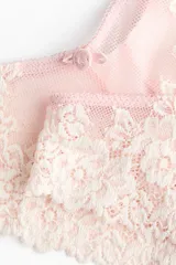 Pack de dos bombachas estilo Brazilian de tiro bajo, confeccionadas en malla translúcida y encaje floral en tonos rosados, con detalle de pequeño moño en la cintura.