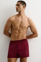 Pack de dos calzoncillos tipo boxer en tejido suave, con cintura elástica y bragueta de botones. Uno de ellos presenta un patrón a cuadros pequeños en tonos rojo y blanco, mientras que el otro cuenta con un diseño de cuadros tipo tartán en tonos rojo y negro.