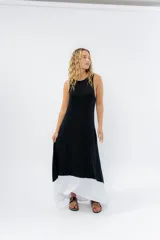 Vestido largo negro con base blanca, de corte suelto y sin mangas.