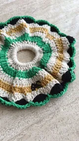 Colita de pelo tejida a crochet con hilo de algodón en color crema y borgoña, con borde rosa.