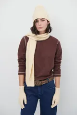 Remera de manga larga con cuello redondo, confeccionada en tejido de punto gris melange con costuras visibles en contraste.
