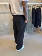 Pantalón sastrero de vestir color negro, de corte ancho y holgado, con pinzas frontales en la cintura y bolsillos laterales.