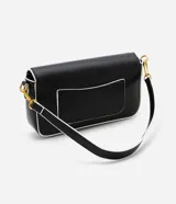 Bolso negro tipo baguette con correa de cadena dorada y correa corta blanca. Tiene cierre de tapa con broche dorado con el logo STN.