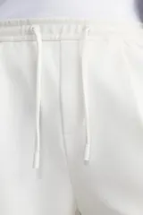 Bermuda negra de corte recto, con cintura elástica ajustable mediante cordón, pliegues frontales y bolsillos de vivo en la espalda. El bajo tiene un dobladillo vuelto.