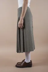 Falda midi gris con diseño de espiga, corte evasé y abertura frontal.