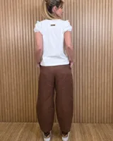 Pantalón de lino color marrón con corte barrel, tiro medio, cintura elástica con cordón de ajuste y bolsillos laterales.