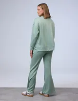 Buzo blanco de tejido elastizado, con pespunte central en la parte delantera y tajos laterales.