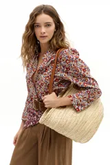 Camisa de popelina 100% algodón con estampado floral multicolor en tonos rojos, azules y amarillos sobre fondo blanco. Presenta cuello clásico camisero, hombros abullonados, mangas largas y botones de nácar en el frente.