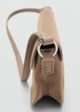 Bolso de hombro tipo baguette confeccionado en piel de serraje color tostado. Presenta un diseño rectangular con solapa frontal decorada con un detalle metálico y pespuntes visibles. Incluye un asa fija y forro interior.