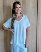 Remera blanca de algodón tramado, con escote en V y mangas cortas holgadas con dobladillo.