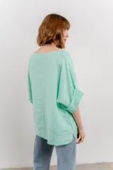 Blusa de lino color verde oliva, de corte amplio y relajado, con escote redondo y mangas 3/4 remangadas.