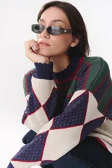 Buzo de tejido de punto con diseño geométrico y combinación de colores en contraste. Presenta cuello redondo, mangas largas y corte oversized.