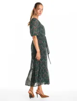 Vestido midi de gasa estampada con diseño de hojas, escote en V cruzado y mangas cortas fluidas. Presenta cintura elastizada con lazo ajustable y falda con volados escalonados que aportan movimiento. Incluye forro interno a tono.