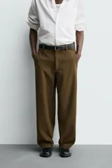 Pantalón de corte balloon fit, color negro, con bolsillos laterales de vivo y bolsillos traseros con solapa. Presenta cierre frontal con cremallera y botón.
