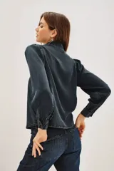 Camisa de liocel color gris oscuro con bordado de flores negras en las mangas largas abullonadas.