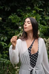 Traje de baño enterizo negro con lunares blancos, de un solo hombro y con abertura en el pecho.