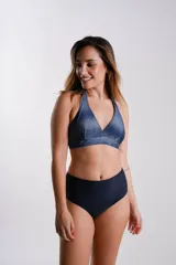 Conjunto de bikini con corpiño triangular con estampado abstracto en tonos violeta, rosa y negro, y bombacha tiro alto negra.