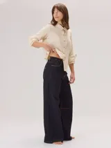 Pantalon de corte ancho y holgado, color verde militar, con diseño de tiro medio, pinzas decorativas debajo de la rodilla, bordado de monograma en el bolsillo delantero y costuras a contratono.