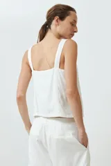 Top blanco de breteles anchos y escote cuadrado con detalle de bordado calado.