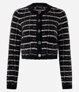 Cardigan cropped negro con diseño de tweed a cuadros blancos, con cuello redondo y cierre frontal con botones esmaltados.