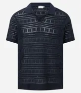 Remera tipo polo de manga corta con cuello en V, confeccionada en un tejido con textura patchwork. Presenta un diseño elegante y versátil, ideal para un look casual o formal.