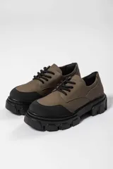 Zapato acordonado de cuero negro con suela track.