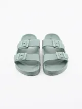 Sandalia tipo 'slide' de una sola tira ancha, color verde menta, con hebilla ajustable de dos pines.