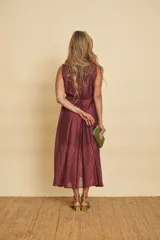 Vestido midi sin mangas de color mostaza, con escote en V cruzado y un lazo ajustable en la cintura.