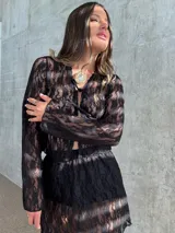 Falda corta de encaje negro con diseño semitransparente y cintura elástica.
