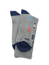 Medias de largo medio color gris melange con estampado de motivos de barbería, incluyendo tijeras, peines, navajas, bigotes y postes de barbero. Presenta talón y puntera en color azul marino.