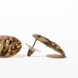 Par de caravanas doradas con diseño texturizado.