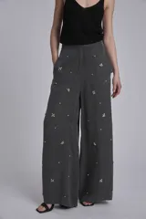 Pantalón palazzo gris con apliques de lentejuelas y mostacillas formando flores.