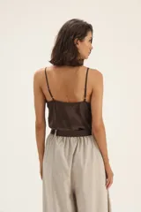 Musculosa negra de seda con escote en V y detalle de flecos en el escote.