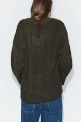 Jersey de punto con diseño de ochos, cuello en pico y manga larga, de corte oversize.