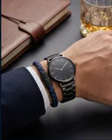 Pulsera de diseño trenzado que combina cuero sintético en tonos azul y negro, con cierre magnético de acero inoxidable.
