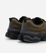 Championes estilo dad sneaker en color verde militar, con recortes en gamuza sintética y malla técnica. Presenta suela alta de goma termoplástica en color negro y cierre con cordones.