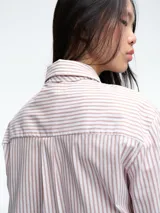 Camisa de corte clásico con estampado de rayas verticales azules y blancas, cuello camisero y cierre frontal con botones. Incluye una corbata a juego con el mismo estampado.