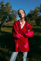 Cárdigan rojo de lana merino con bordados florales fucsia hechos a mano.