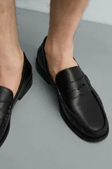 Mocasín de vestir fabricado en piel color bordó, con detalle de antifaz en el empeine y suela a tono con ligero tacón.
