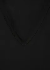 Camiseta negra de manga corta, con cuello en V y diseño recto de tejido fluido.