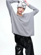 Sweater de punto color gris, con escote en V profundo, hombros caídos y diseño holgado de corte relajado.