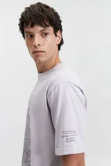 Remera de manga corta color lila, de corte regular y escote redondo, con estampa frontal de líneas topográficas y texto.