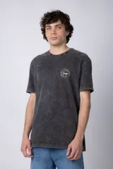 Remera de algodón color gris oscuro con efecto acid wash, corte semi-oversize y cuello redondo. Presenta un pequeño estampado circular en el pecho con un diseño de girasoles y texto.