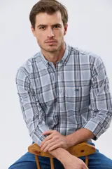 Camisa de manga larga de calce slim, con diseño a cuadros en tonos azul oscuro, verde y blanco. Presenta cuello camisero con botones y bolsillo ojal en el pecho con detalle bordado.
