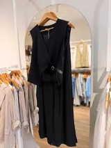 Conjunto de dos piezas para mujer en color beige, compuesto por un chaleco cruzado sin mangas con cinturón lateral y un pantalón de corte amplio.